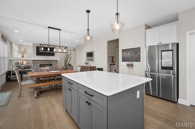 207 Castle Stuart Ct, Dardenne Prairie, MO 63368 - kitchen featuring smart refrigerator, gray cabinets, light wood finished floors, a fireplace, and recessed lighting
