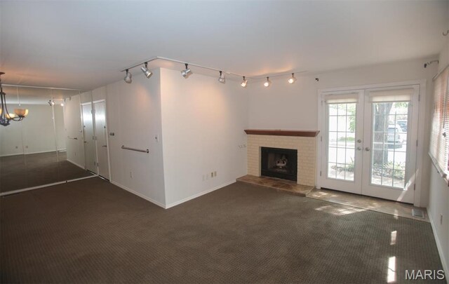 1340 Holgate Dr Unit F2, Ballwin, MO 63021 - unfurnished living room with track lighting, carpet, french doors, and a fireplace