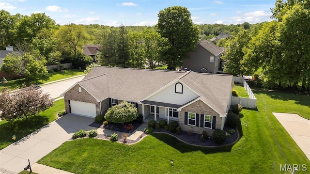 view of front of house featuring concrete driveway, a front yard, an attached garage, a shingled roof, and stone siding