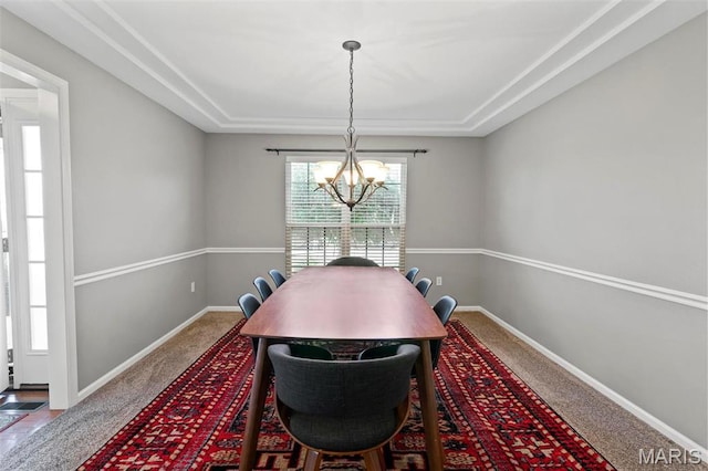 dining room with a raised ceiling, a chandelier, carpet floors, and baseboards