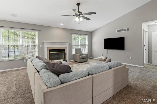 living area featuring carpet floors, a ceiling fan, vaulted ceiling, baseboards, and a glass covered fireplace