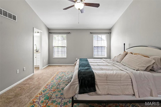 bedroom featuring carpet, baseboards, lofted ceiling, a ceiling fan, and ensuite bathroom