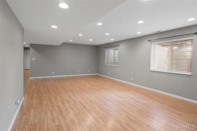 unfurnished room with baseboards, light wood-style flooring, and recessed lighting