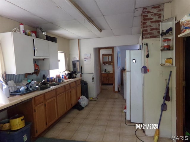 2163 Welch Dr, Hermann, MO 65041 - kitchen with freestanding refrigerator, a paneled ceiling, light countertops, and a sink