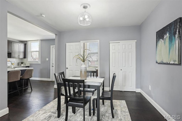 5327 W Ave, Saint Louis, MO 63116 - dining space featuring baseboards, dark wood finished floors, and a chandelier