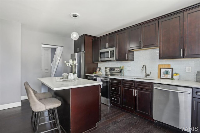 5327 W Ave, Saint Louis, MO 63116 - kitchen with appliances with stainless steel finishes, a sink, a kitchen breakfast bar, a kitchen island, and backsplash
