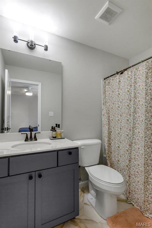 bathroom featuring toilet, vanity, and a shower with shower curtain