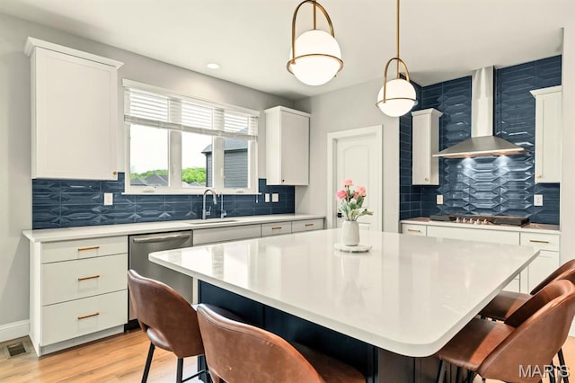 215 Everett Creek Ct, Lake St Louis, MO 63367 - kitchen featuring wall chimney exhaust hood, appliances with stainless steel finishes, a kitchen breakfast bar, decorative backsplash, and recessed lighting