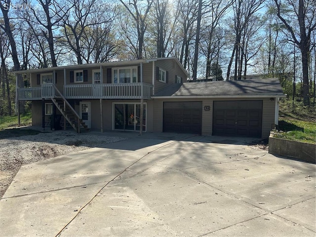 view of front of home featuring an attached garage, stairs, driveway, and covered porch
