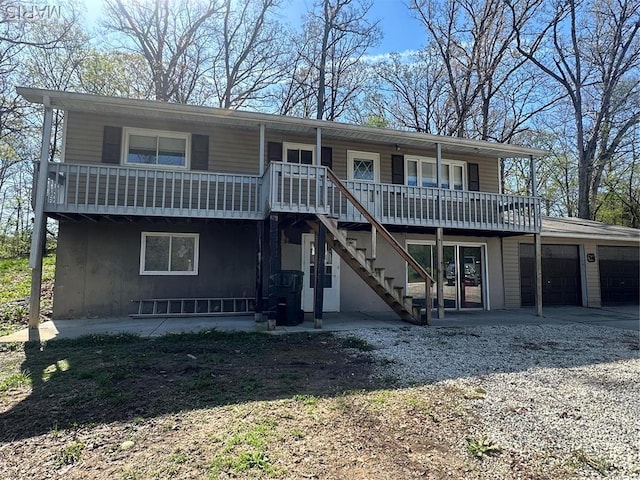 view of front of home with an attached garage, driveway, and stairway