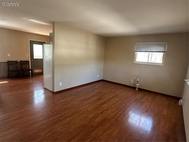 spare room featuring healthy amount of natural light, wood finished floors, and baseboards