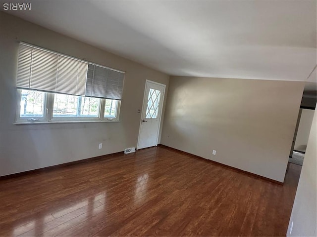 unfurnished living room with wood finished floors and baseboards