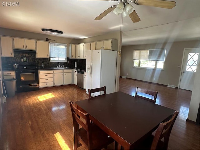 dining space with healthy amount of natural light, dark wood-style floors, ceiling fan, and baseboards