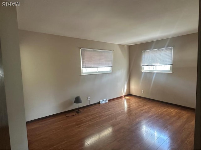 spare room with wood finished floors and baseboards