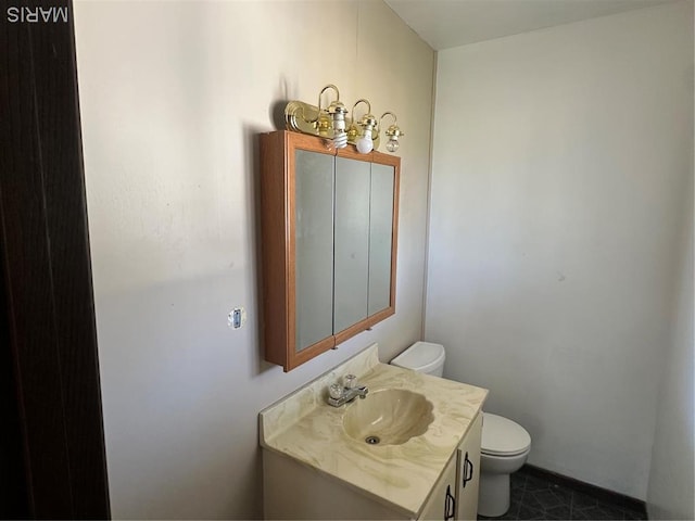 half bath featuring toilet, vanity, and baseboards