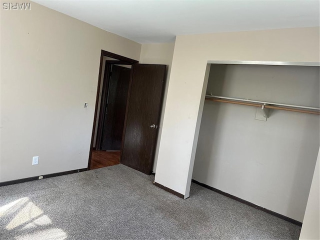 unfurnished bedroom featuring carpet, a closet, and baseboards