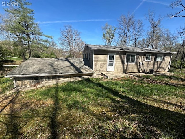 back of property featuring a lawn and a patio