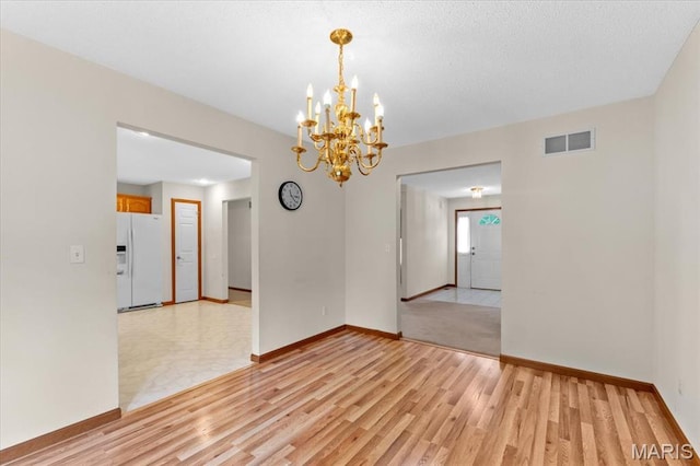 2305 Loretta Ln, Collinsville, IL 62234 - unfurnished room featuring a chandelier, light wood-style floors, and baseboards