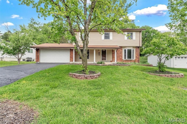 view of front facade featuring brick siding, asphalt driveway, an attached garage, and a front lawn