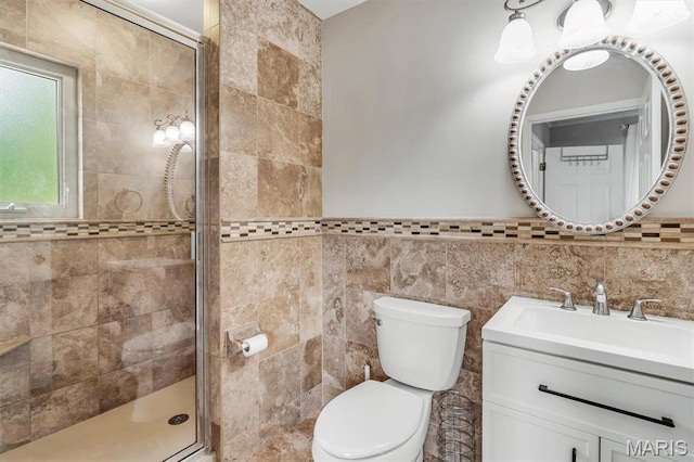 bathroom with a shower stall, toilet, tile walls, and vanity