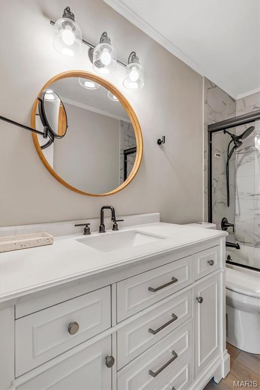 full bathroom featuring ornamental molding, vanity, toilet, shower / bath combination with glass door, and wood finished floors