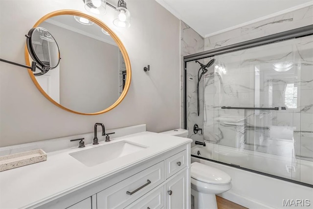 bathroom featuring crown molding, toilet, bath / shower combo with glass door, and vanity