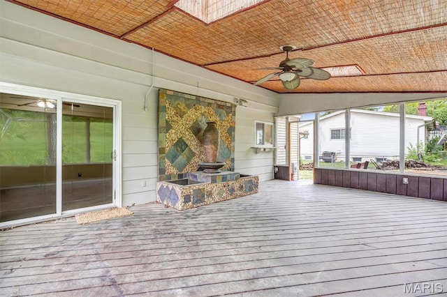 sunroom featuring a ceiling fan and a skylight