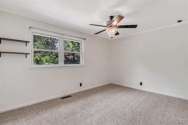 empty room with ceiling fan, carpet, baseboards, and ornamental molding