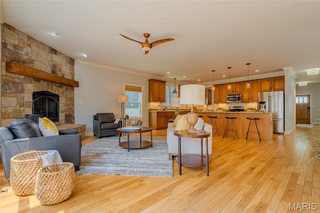 734 Fuhrmann Ter, Glendale, MO 63122 - living room featuring light wood-style flooring, ornamental molding, a ceiling fan, a fireplace, and recessed lighting