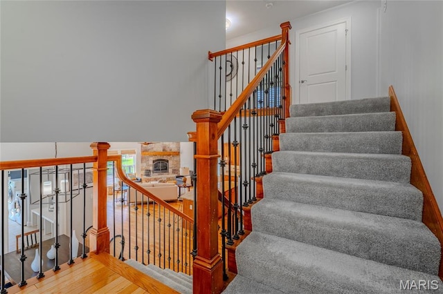 734 Fuhrmann Ter, Glendale, MO 63122 - staircase featuring wood finished floors and a stone fireplace