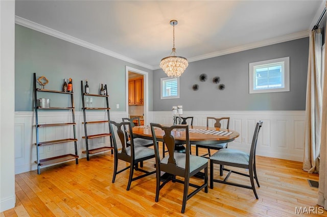 734 Fuhrmann Ter, Glendale, MO 63122 - dining space featuring light wood-type flooring, a wainscoted wall, a chandelier, and crown molding