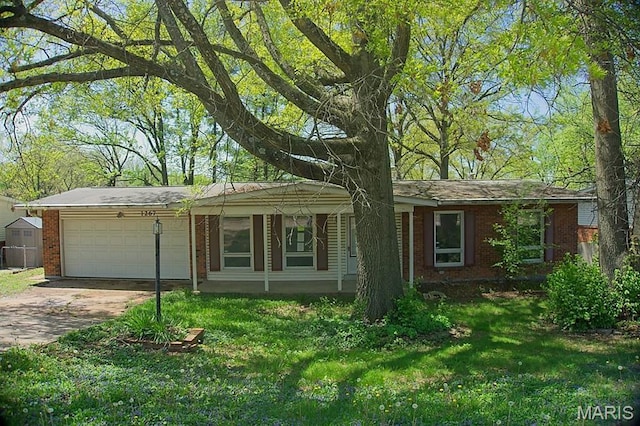 ranch-style home featuring a garage, brick siding, driveway, and a front lawn