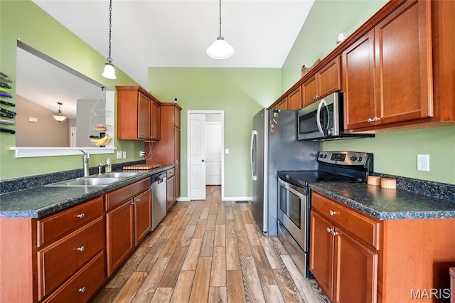 6346 Twin Springs Blvd, Cedar Hill, MO 63016 - kitchen with stainless steel appliances, a sink, dark countertops, light wood-style flooring, and pendant lighting