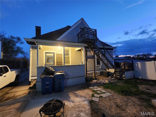 420 E 9th St, Alton, IL 62002 - back of property at dusk featuring stairs, a chimney, fence, and a fire pit