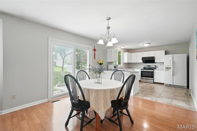 16816 Hickory Trails Ln, Wildwood, MO 63011 - dining area with baseboards, light wood finished floors, and a chandelier