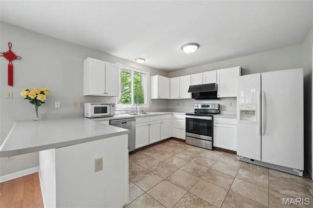 16816 Hickory Trails Ln, Wildwood, MO 63011 - kitchen with appliances with stainless steel finishes, a peninsula, under cabinet range hood, a sink, and white cabinets