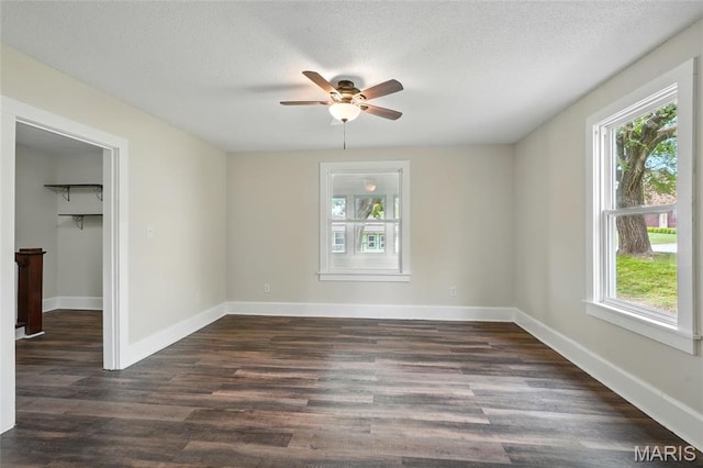 1242 Crystal Heights Rd, Crystal City, MO 63019 - unfurnished bedroom with multiple windows, dark wood-style flooring, a spacious closet, baseboards, and a textured ceiling