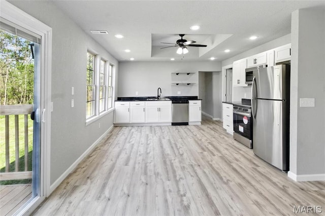 619 E 3rd St, De Soto, MO 63020 - kitchen with stainless steel appliances, a sink, dark countertops, baseboards, and light wood finished floors