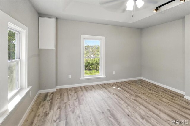 619 E 3rd St, De Soto, MO 63020 - spare room with healthy amount of natural light, light wood-type flooring, ceiling fan, and baseboards