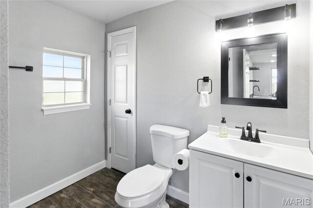 619 E 3rd St, De Soto, MO 63020 - bathroom with toilet, vanity, baseboards, and wood finished floors
