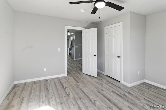 619 E 3rd St, De Soto, MO 63020 - unfurnished bedroom featuring wood finished floors, freestanding refrigerator, baseboards, attic access, and ceiling fan