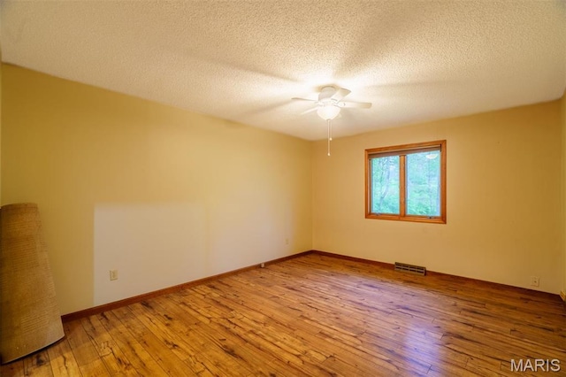 10280 County Road 3110, Rolla, MO 65401 - empty room with a ceiling fan, hardwood / wood-style floors, a textured ceiling, and baseboards