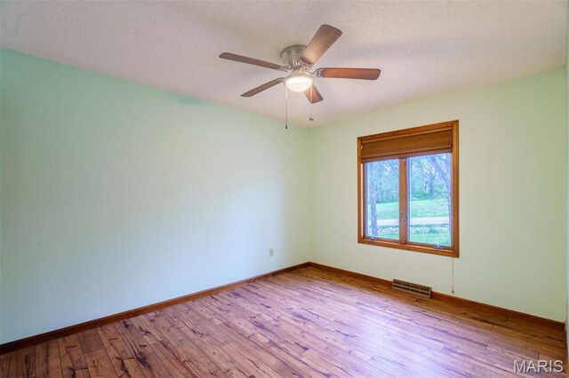 10280 County Road 3110, Rolla, MO 65401 - unfurnished room featuring hardwood / wood-style floors, a ceiling fan, baseboards, and a textured ceiling