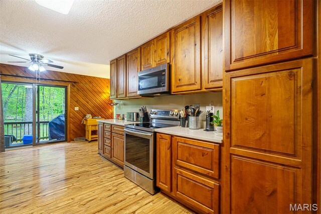 10280 County Road 3110, Rolla, MO 65401 - kitchen with appliances with stainless steel finishes, a textured ceiling, light countertops, brown cabinetry, and light wood-style floors