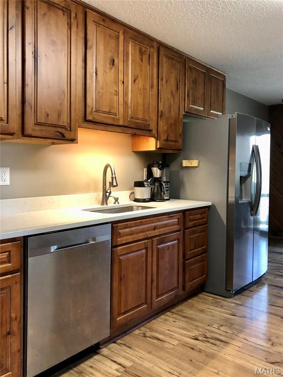 10280 County Road 3110, Rolla, MO 65401 - kitchen featuring appliances with stainless steel finishes, a textured ceiling, a sink, light wood-style floors, and light countertops