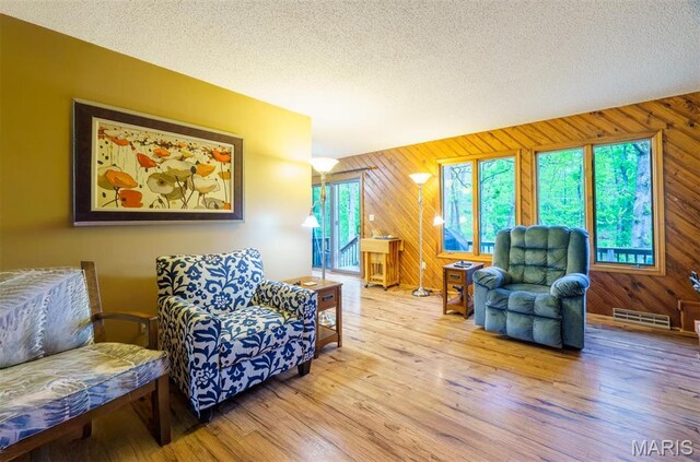 10280 County Road 3110, Rolla, MO 65401 - living room with wood walls, wood finished floors, and a textured ceiling