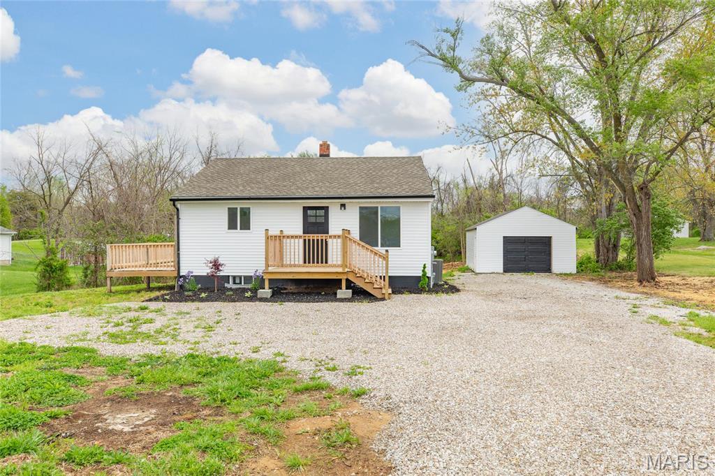 4239 Fosterburg Rd, Alton, IL 62002 - view of front of property with an outdoor structure, a wooden deck, a chimney, gravel driveway, and a detached garage