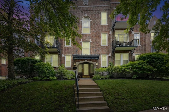 view of front facade with a front lawn and brick siding