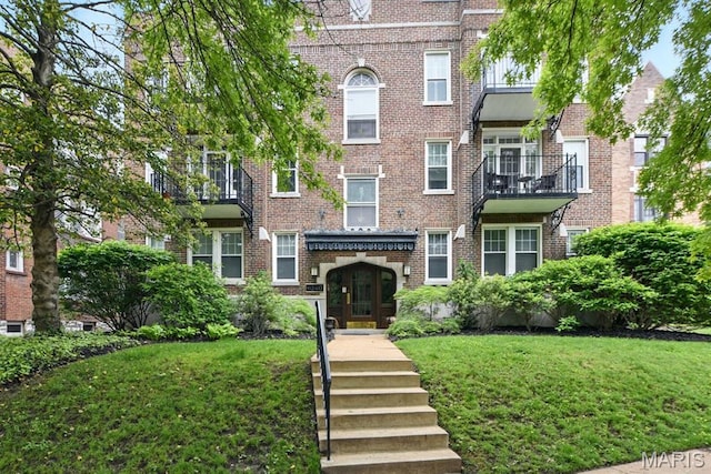 view of front of property with a front lawn and brick siding