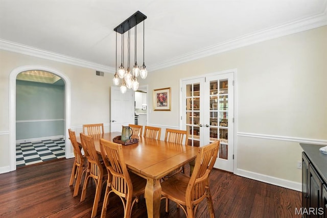 dining space featuring crown molding, french doors, dark wood-type flooring, arched walkways, and baseboards